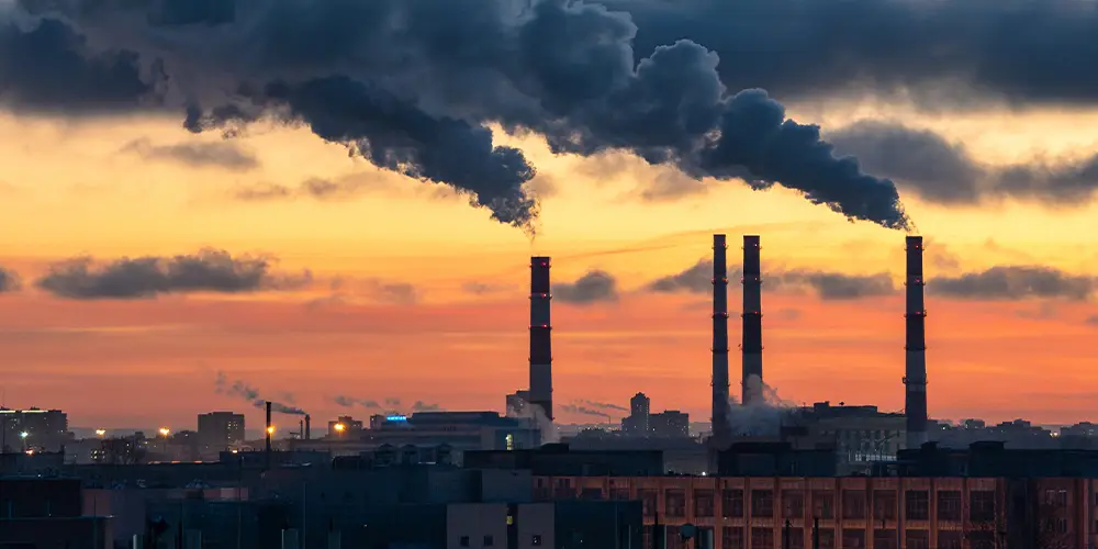 Industrial chimneys generating pollution at dawn.